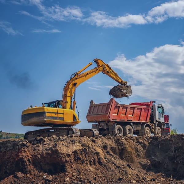 Máquina excavadora cargando tierra en un camión en un sitio de construcción