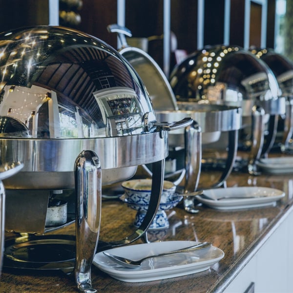 Montaje de buffet con varios platos, representando la industria de servicios de alimentos