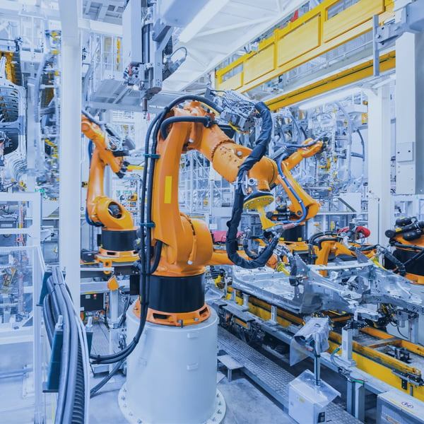 Automated robotic arms in a factory representing industrial automation