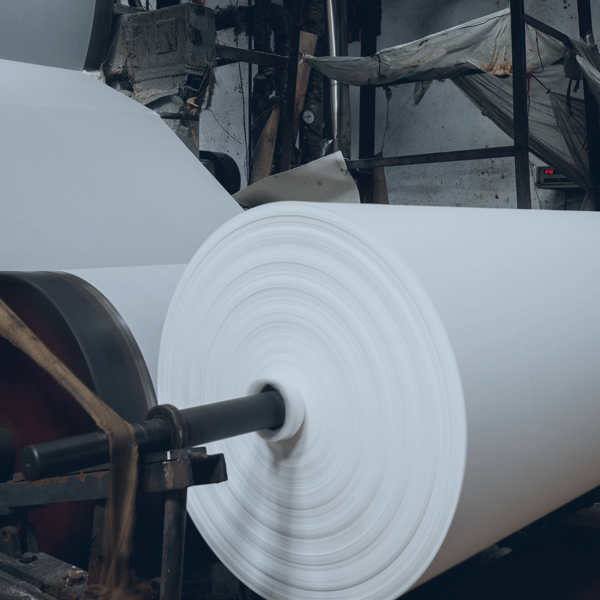 Rollos de papel en movimiento representando la industria del papel